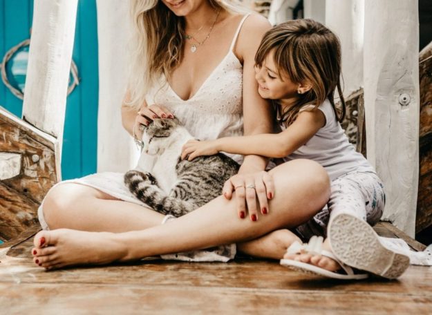 woman-and-her-child-sitting-while-holding-a-cat-2878770